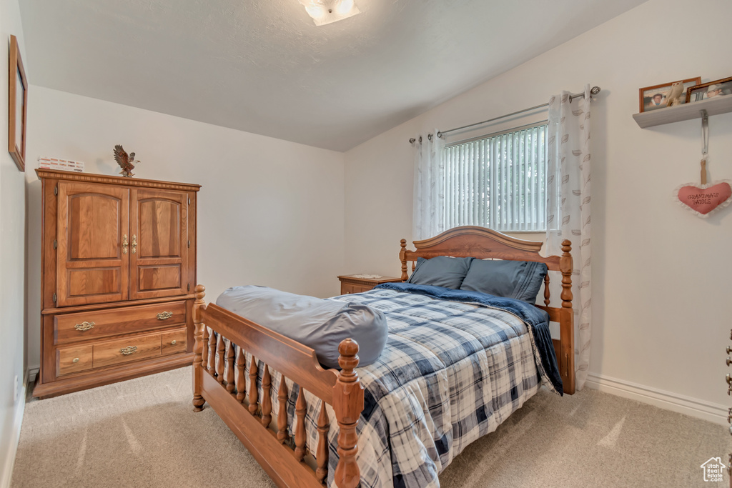 Bedroom featuring light carpet and baseboards