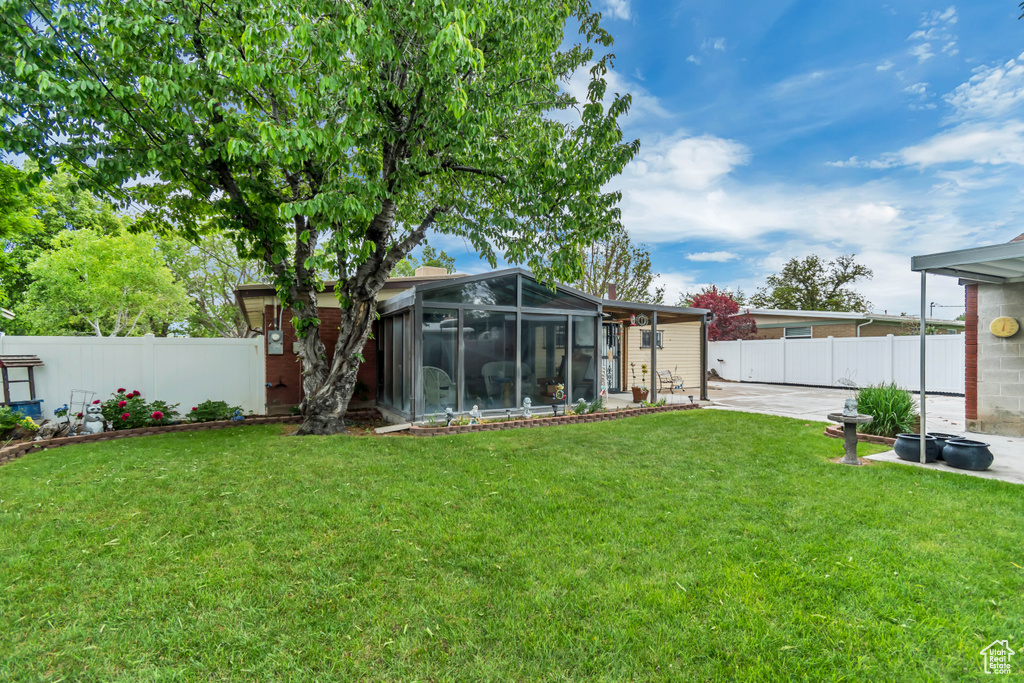 View of yard featuring a sunroom and a patio area