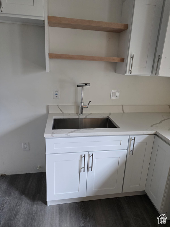 Kitchen featuring dark wood-style floors, a sink, open shelves, and white cabinets