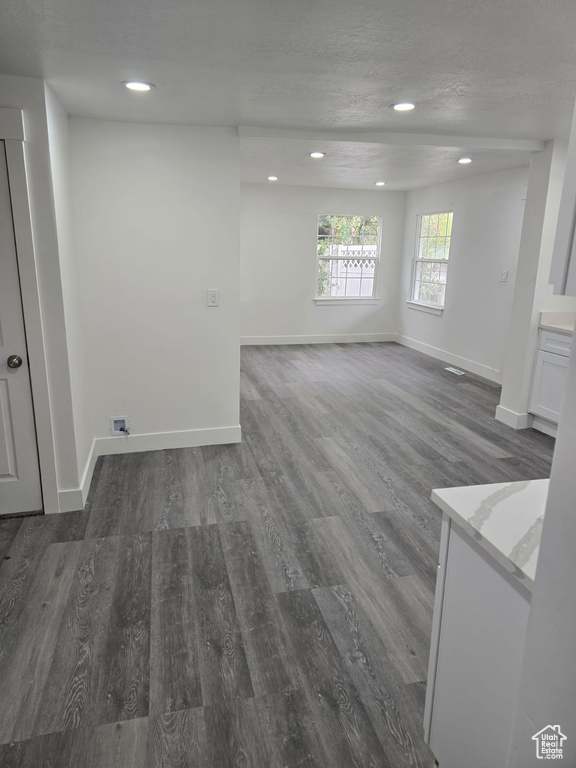 Unfurnished living room featuring wood finished floors, baseboards, and recessed lighting