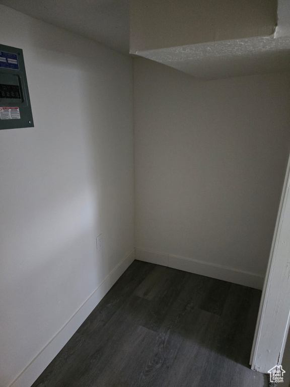 Empty room with dark wood-style flooring and baseboards