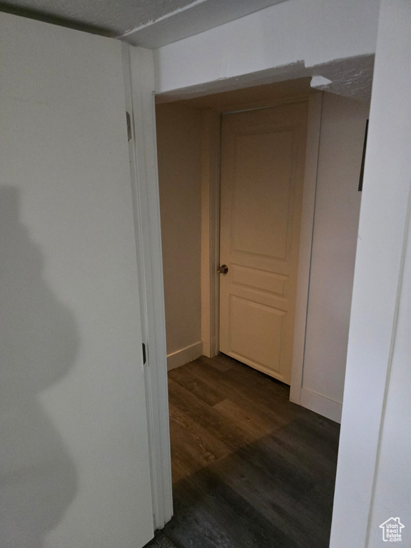 Hallway with dark wood finished floors and baseboards