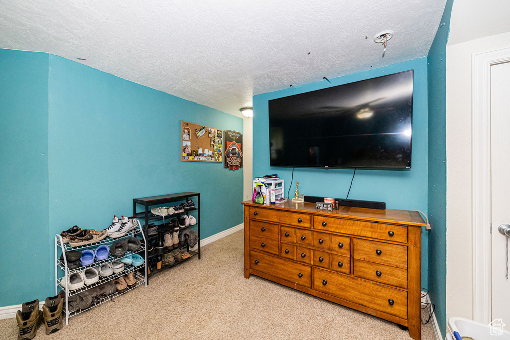 Carpeted bedroom with a textured ceiling and baseboards