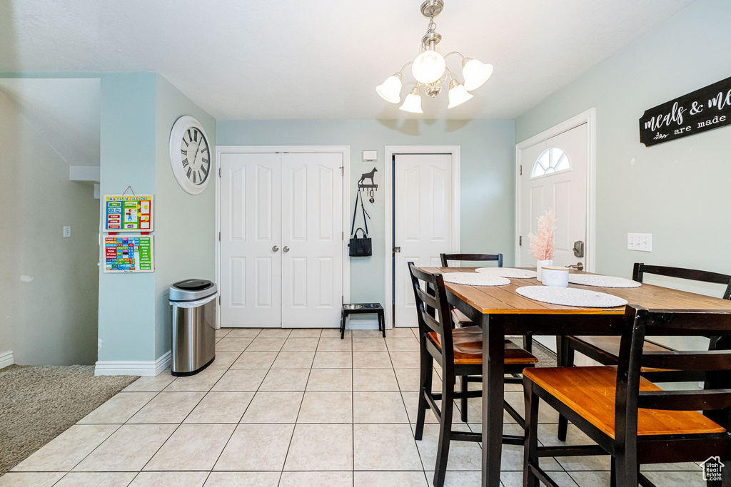 Dining area featuring a chandelier, baseboards, and light tile patterned flooring