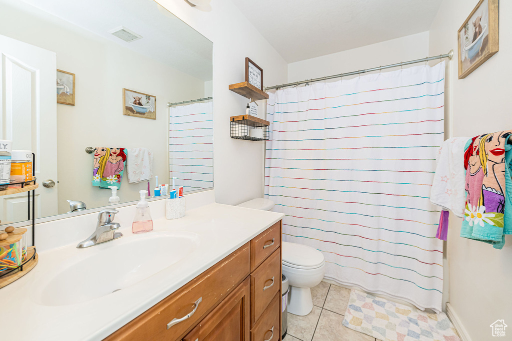 Full bath with toilet, vanity, tile patterned floors, and a shower with curtain