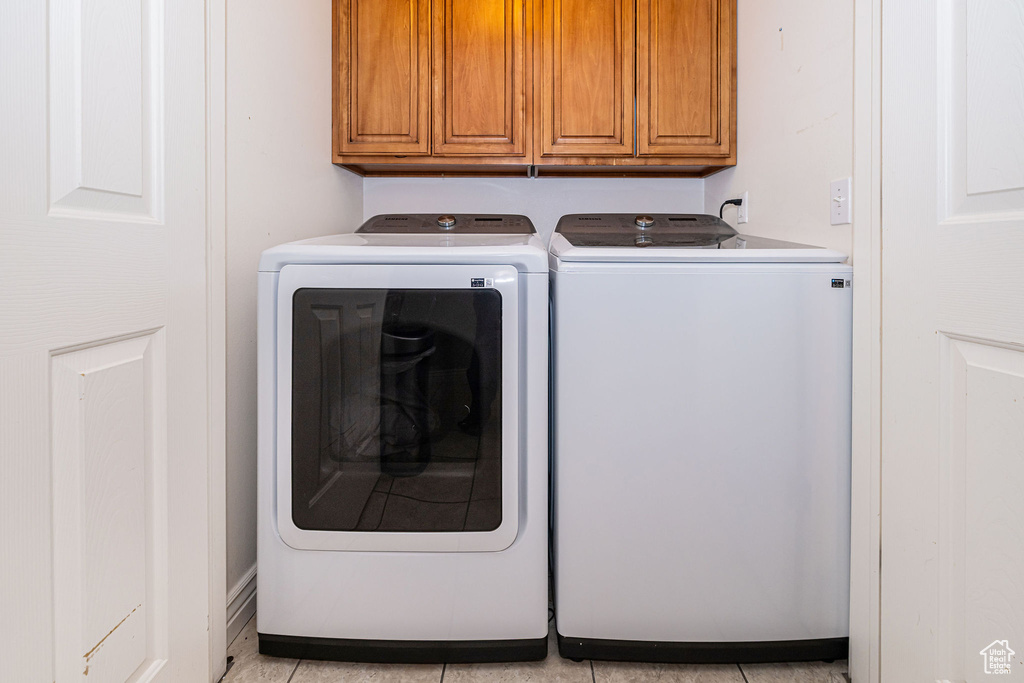 Laundry area featuring washing machine and clothes dryer and cabinet space