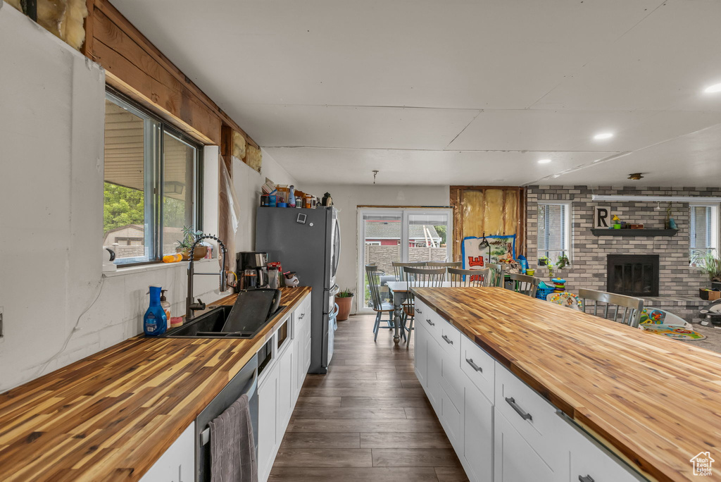 Kitchen featuring wood counters, a sink, dark wood-type flooring, appliances with stainless steel finishes, and white cabinets