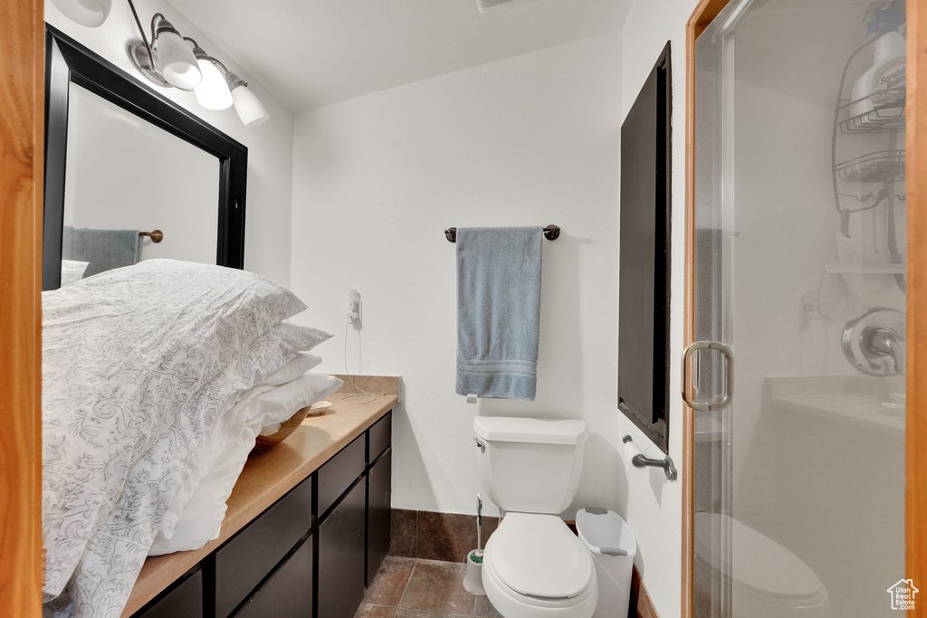 Full bathroom with toilet, a shower stall, vanity, and baseboards