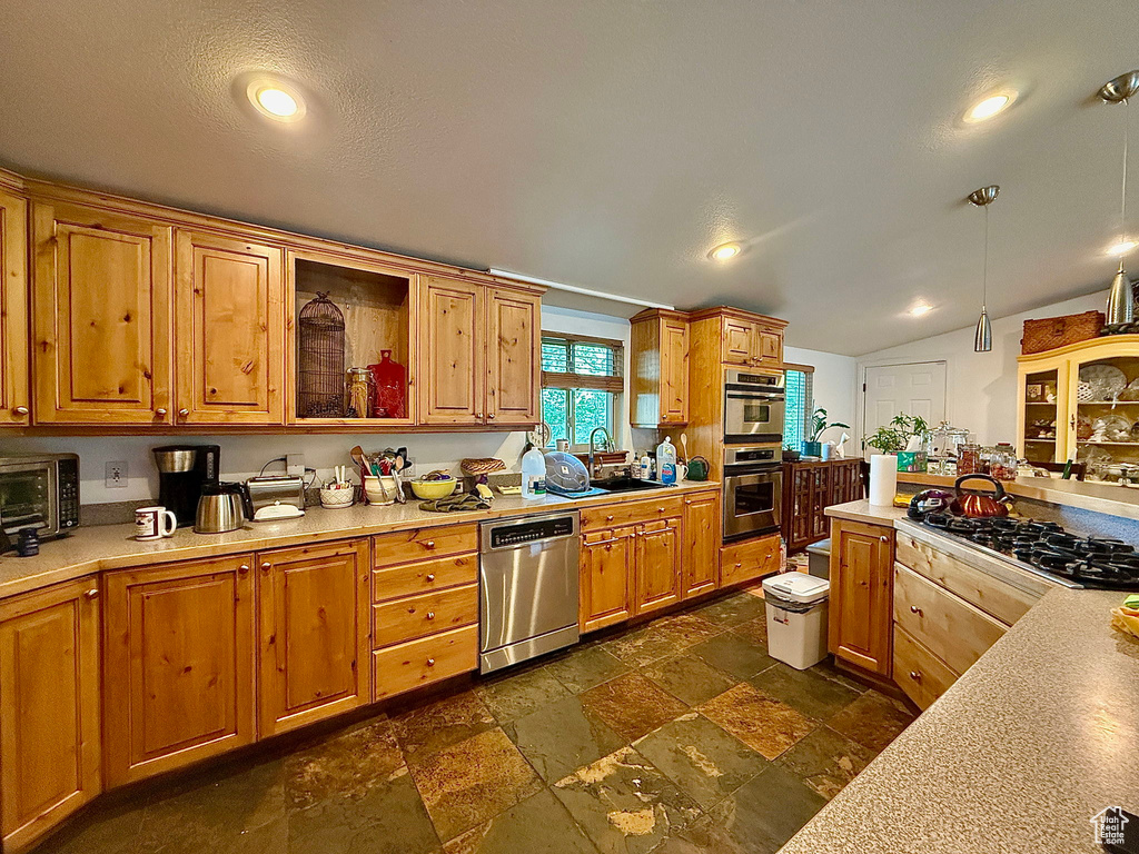 Kitchen featuring dishwasher, a sink, light countertops, stone tile flooring, and black gas stovetop