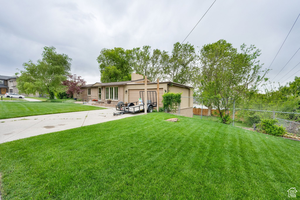 Rear view of property featuring an attached garage and stucco siding