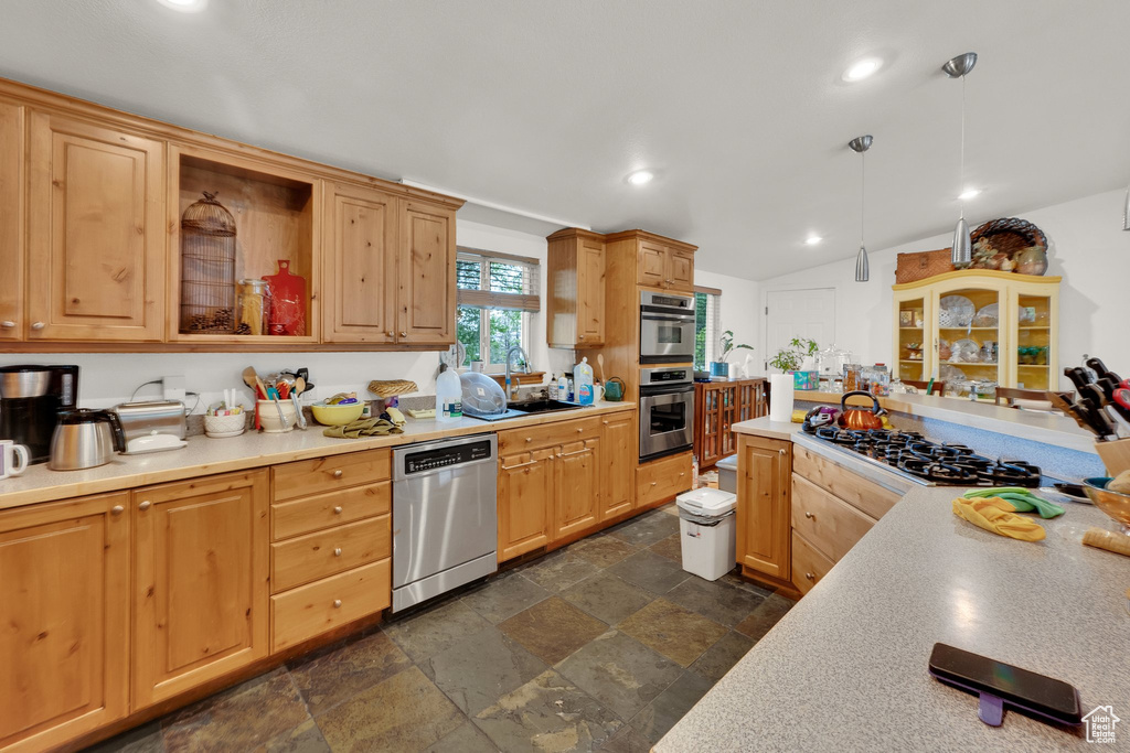 Kitchen featuring appliances with stainless steel finishes, stone tile flooring, a sink, light countertops, and recessed lighting