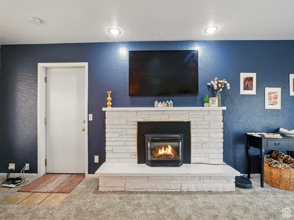 Living room featuring carpet, a glass covered fireplace, recessed lighting, and baseboards