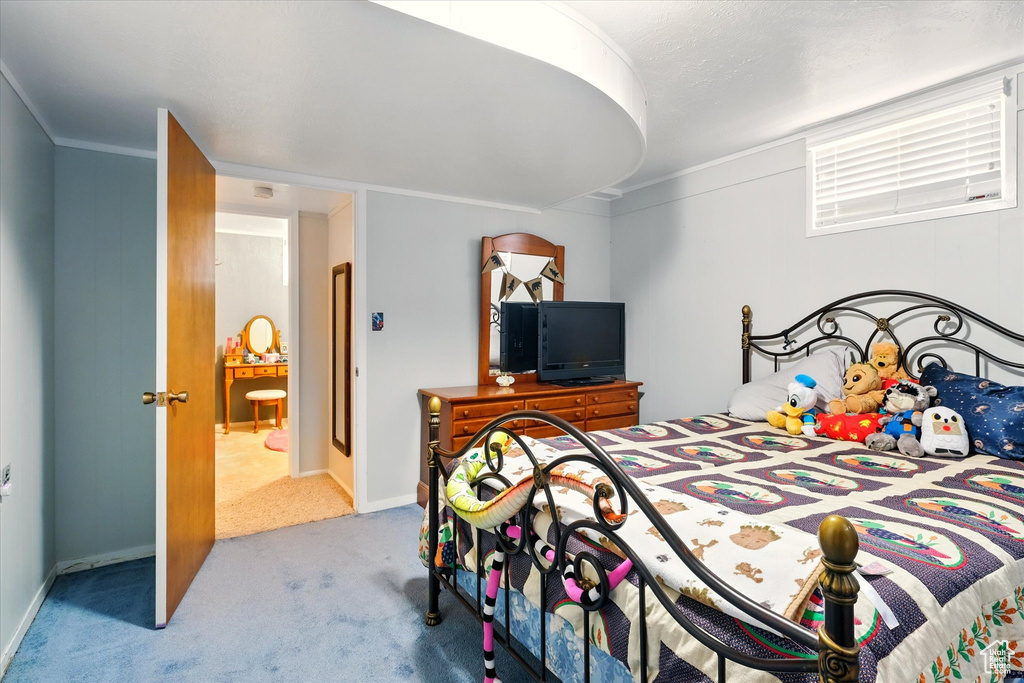 Carpeted bedroom with crown molding and baseboards