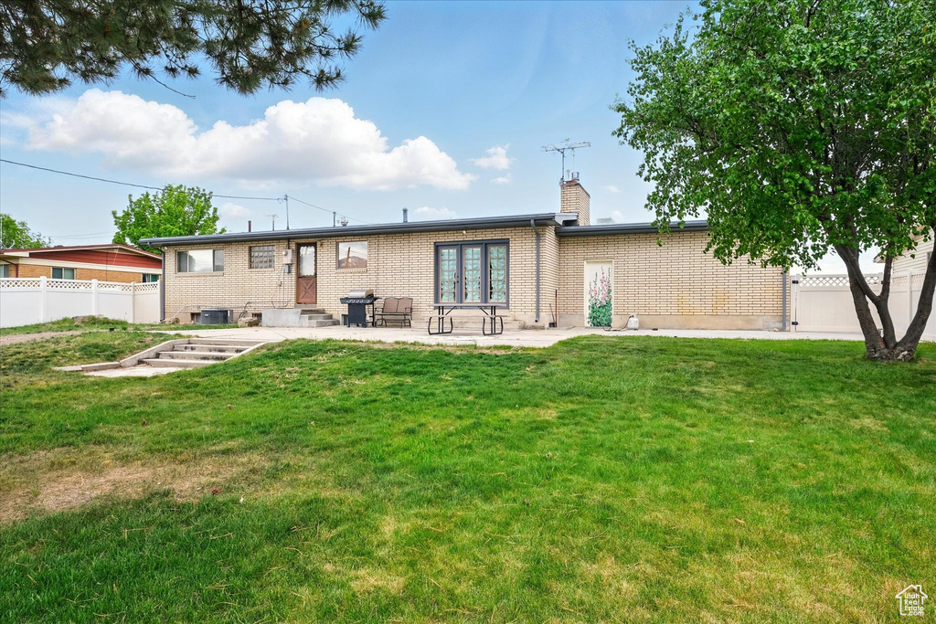 Rear view of property with a chimney, entry steps, brick siding, and a patio area