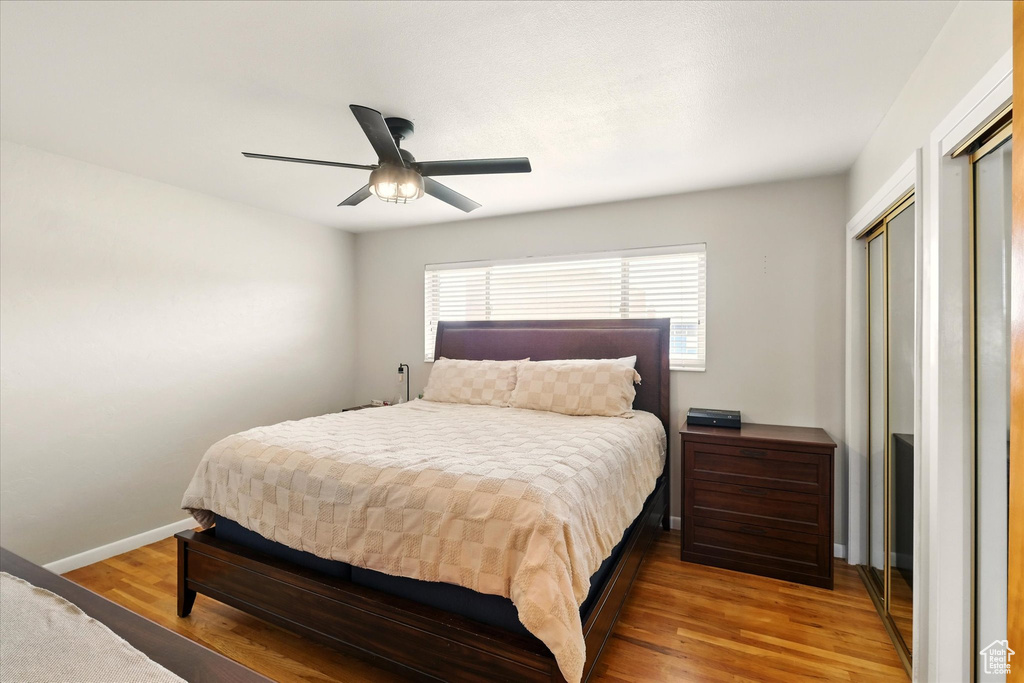 Bedroom featuring wood finished floors, baseboards, and a ceiling fan