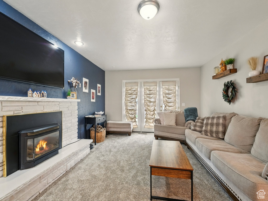 Carpeted living room featuring a glass covered fireplace