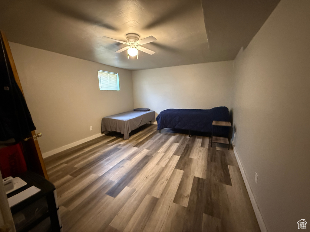 Bedroom featuring baseboards, wood finished floors, and a ceiling fan