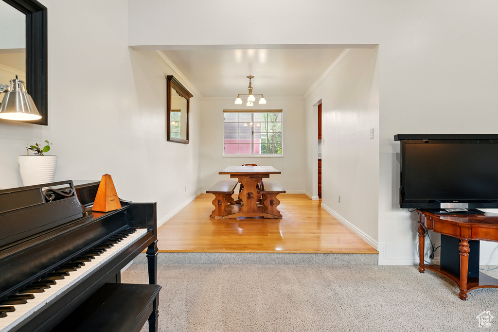 Carpeted foyer entrance with crown molding, a chandelier, and baseboards