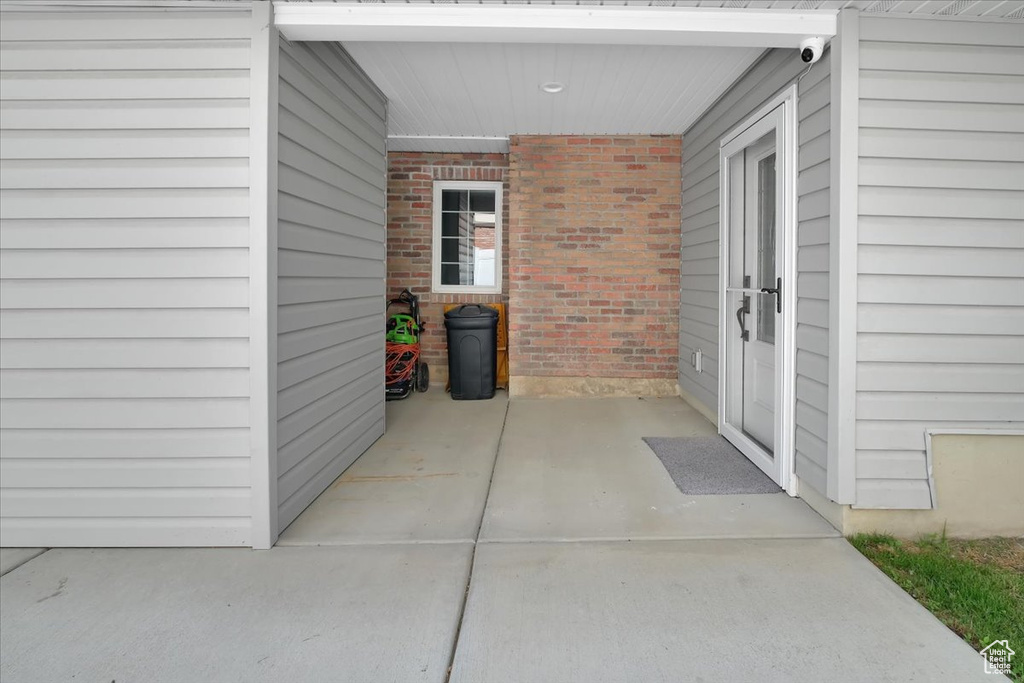 View of exterior entry featuring brick siding and a security system