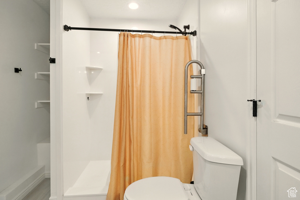Full bath featuring toilet, curtained shower, and recessed lighting