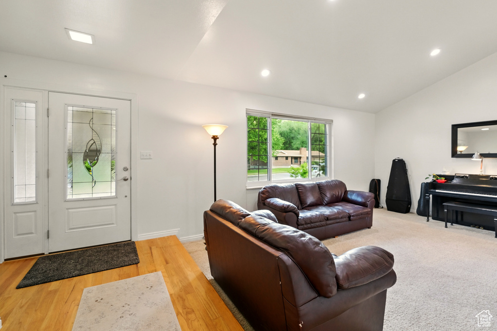 Living area with vaulted ceiling, light wood-type flooring, and recessed lighting