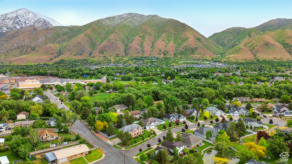 Aerial view of property and surrounding area featuring a mountain backdrop
