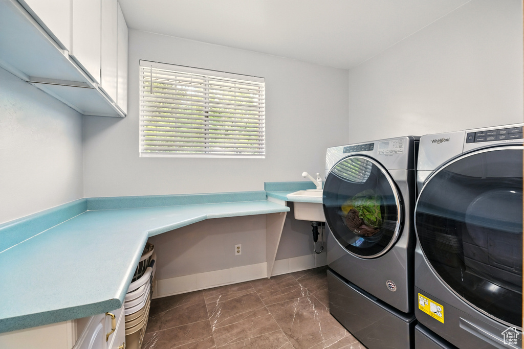 Laundry room with independent washer and dryer, cabinet space, baseboards, and a desk