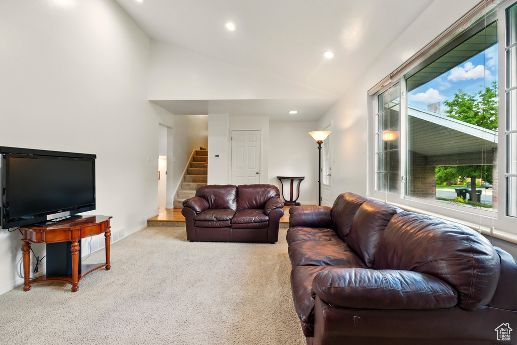 Carpeted living area with stairs, recessed lighting, lofted ceiling, and baseboards