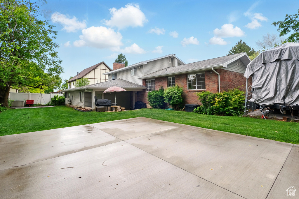 Back of property featuring brick siding and a patio area
