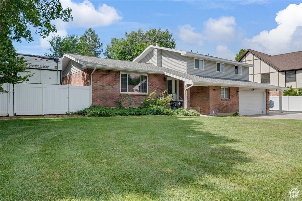 View of front of property featuring brick siding, concrete driveway, and an attached garage
