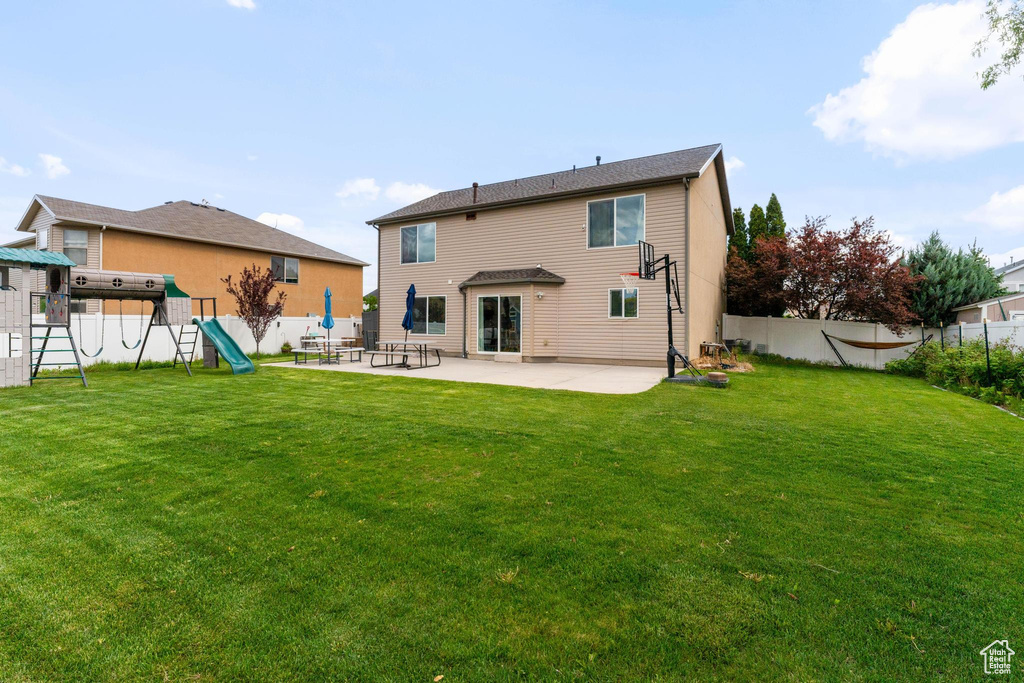 Rear view of property with a patio area and a playground