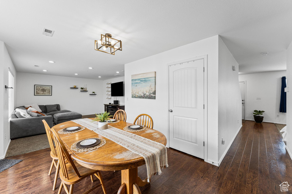 Dining room featuring wood finished floors, baseboards, recessed lighting, and a chandelier
