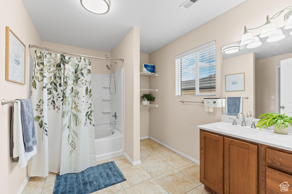 Bathroom featuring tile patterned flooring, vanity, shower / bath combo, and baseboards