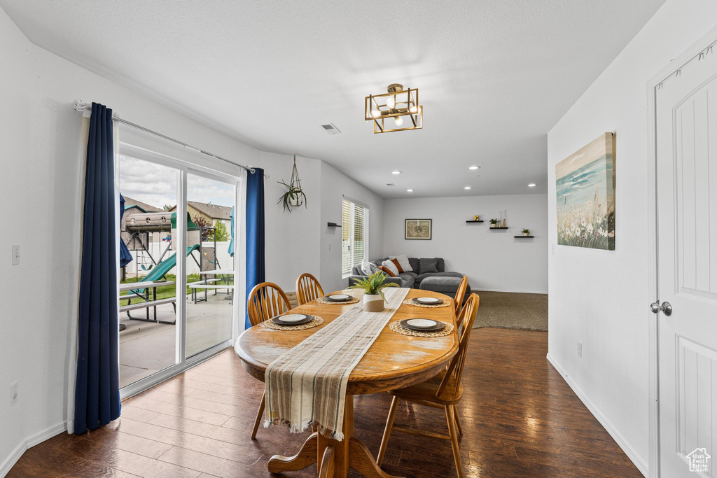 Dining room featuring hardwood / wood-style floors, recessed lighting, and a chandelier