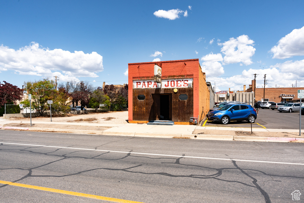 View of building exterior featuring uncovered parking