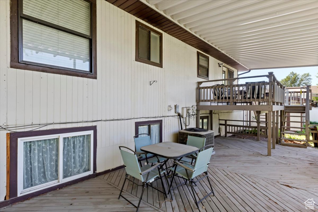 Wooden deck with outdoor dining space and stairs