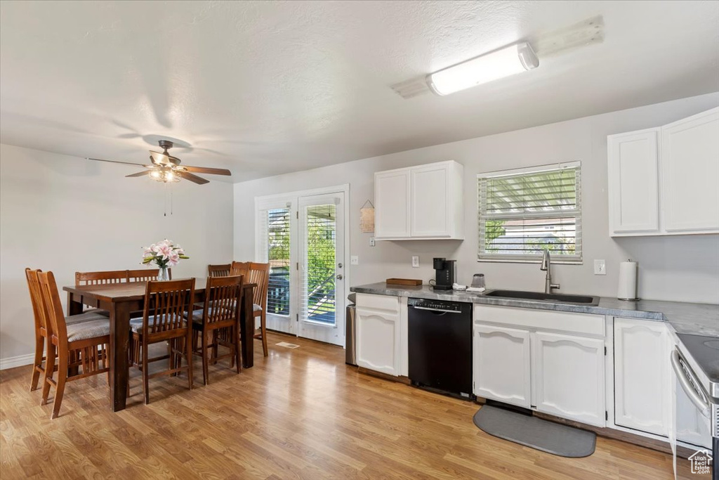 Kitchen with black dishwasher, a sink, white cabinetry, and light wood finished floors