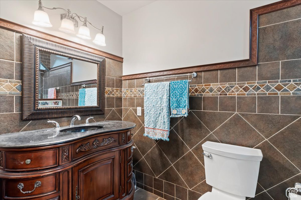 Bathroom with tile walls, toilet, and vanity