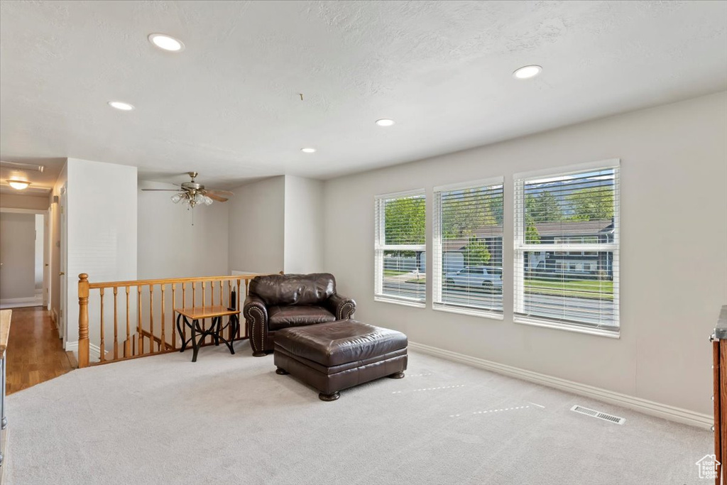 Sitting room featuring an upstairs landing, carpet flooring, recessed lighting, baseboards, and a ceiling fan