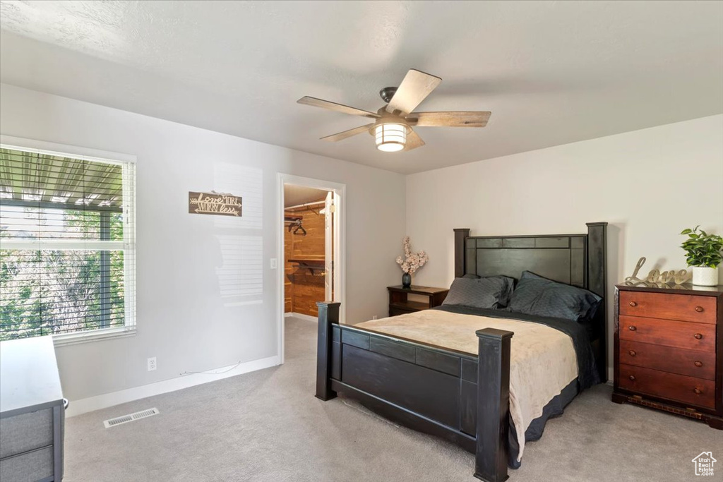 Bedroom featuring light colored carpet, baseboards, and a ceiling fan