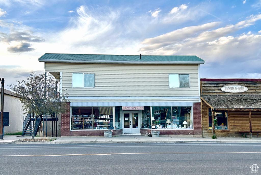 View of front of house with metal roof and brick siding