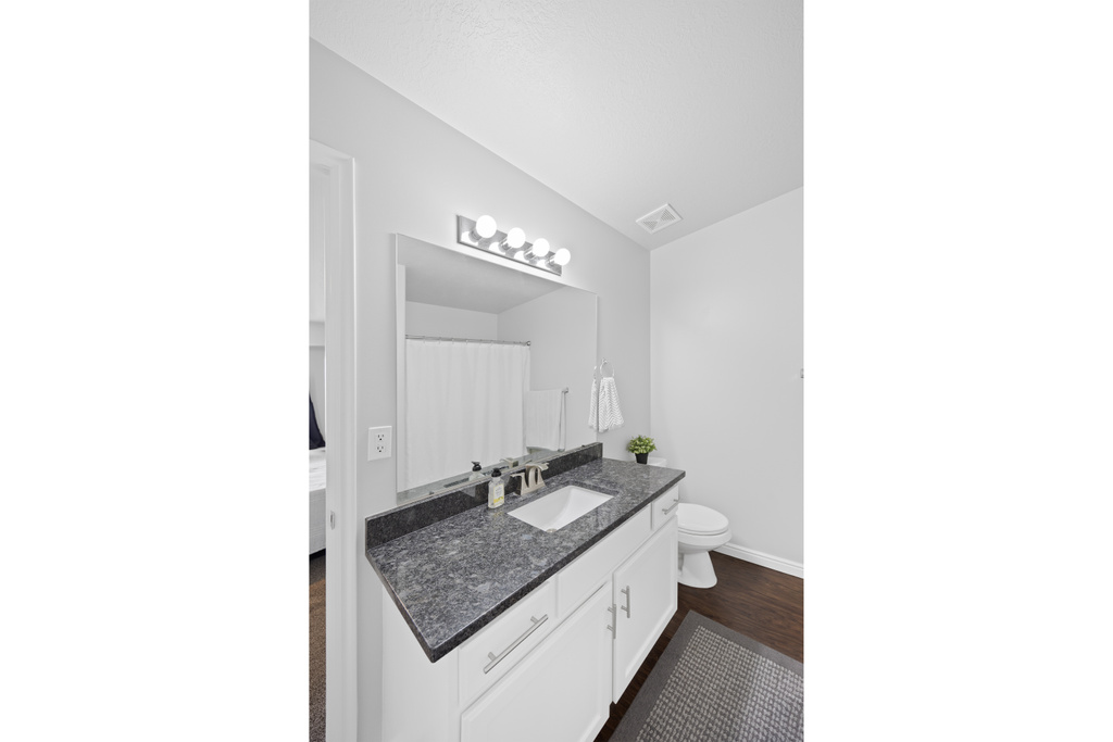 Bathroom featuring vanity, baseboards, and toilet