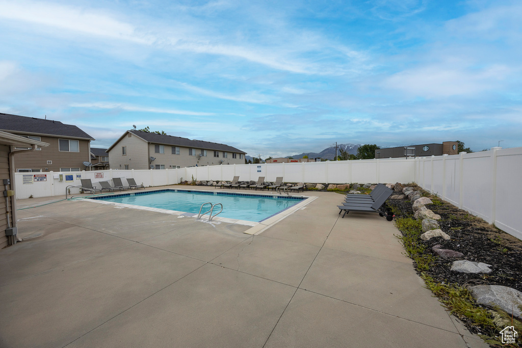 Community pool with a patio and a fenced backyard