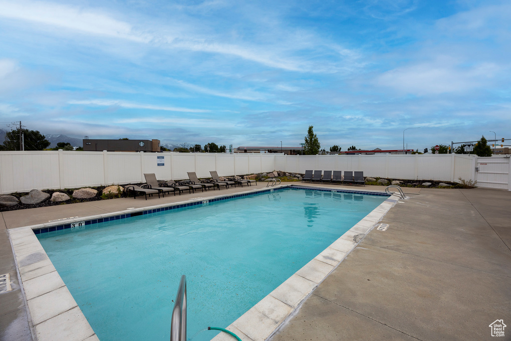 Community pool with a patio and a fenced backyard