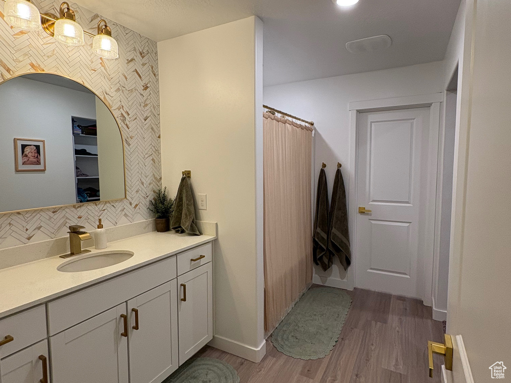 Full bathroom featuring wood finished floors, vanity, recessed lighting, curtained shower, and baseboards