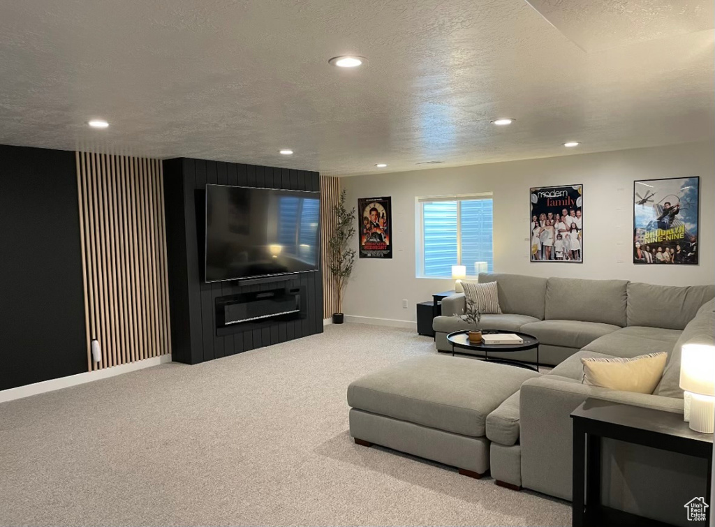 Living room featuring carpet flooring, baseboards, recessed lighting, and a textured ceiling