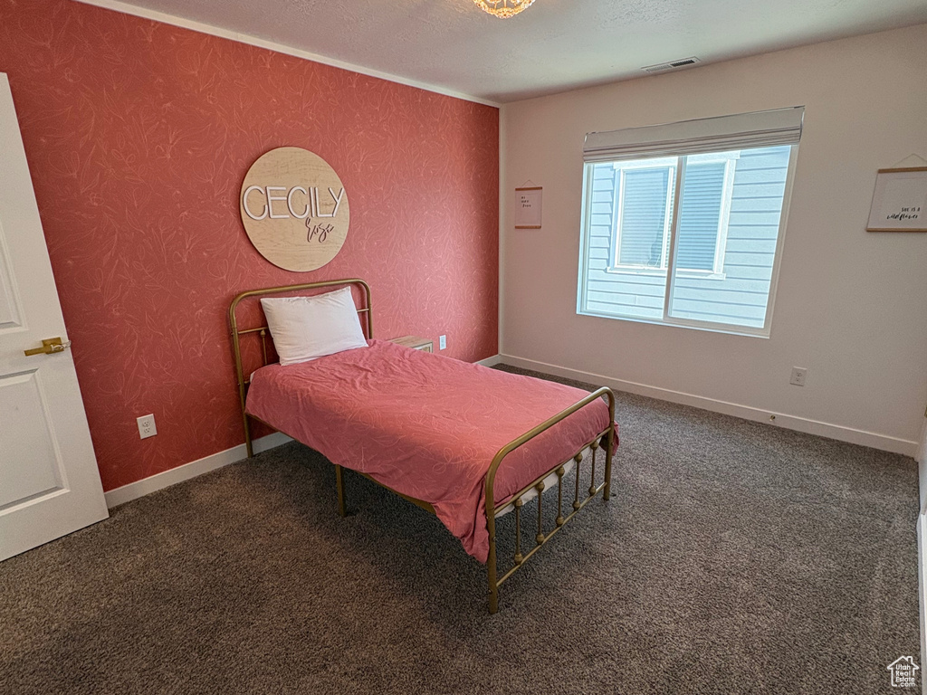 Carpeted bedroom with a textured ceiling and baseboards
