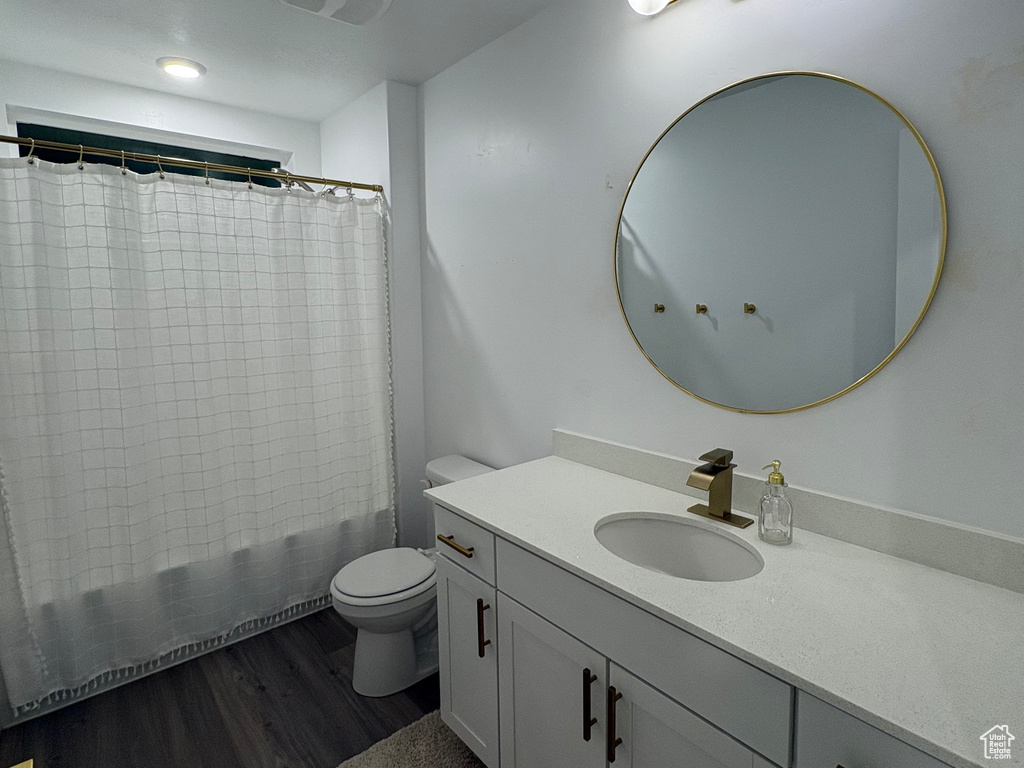 Full bath featuring wood finished floors, vanity, toilet, a shower with curtain, and a textured ceiling