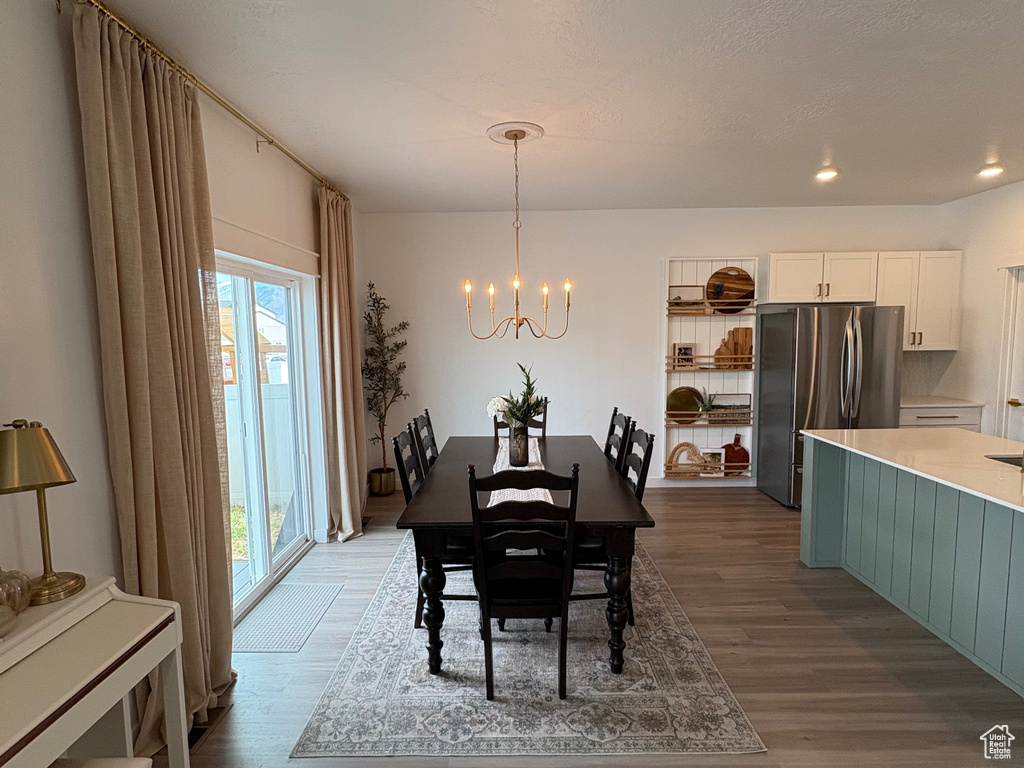Dining space featuring a chandelier, wood finished floors, and recessed lighting