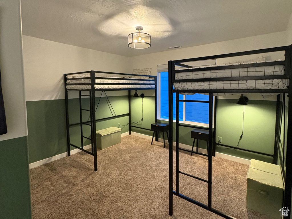 Unfurnished bedroom featuring carpet floors, baseboards, and a textured ceiling